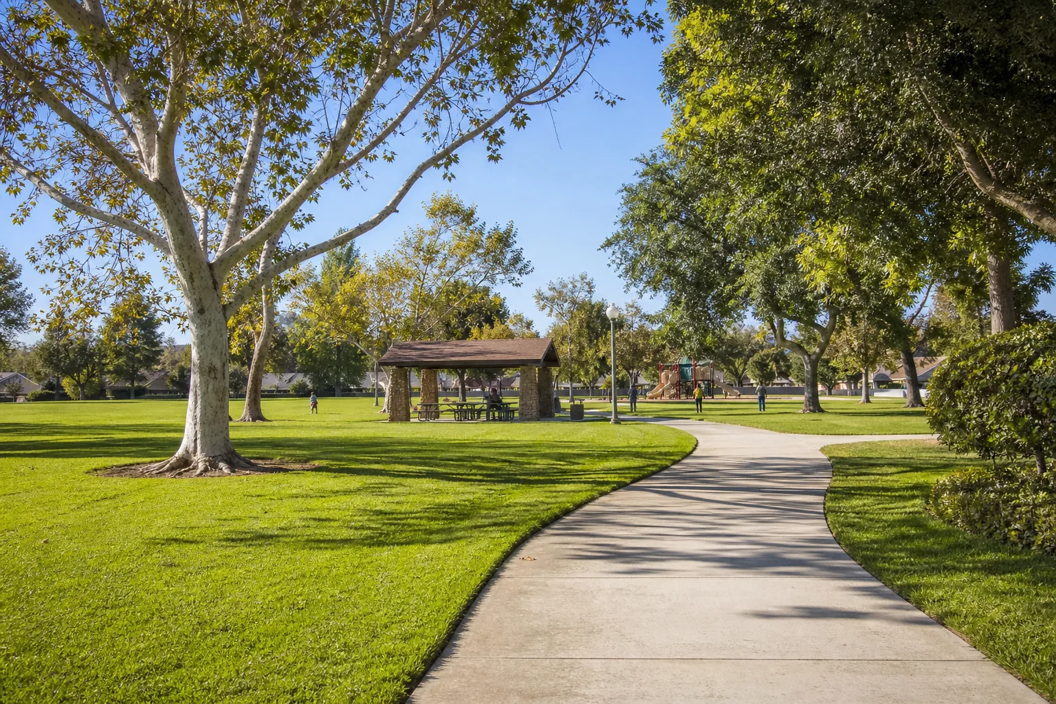 Tree-lined walking path, lawn, and picnic pavilion at Central Park in La Palma