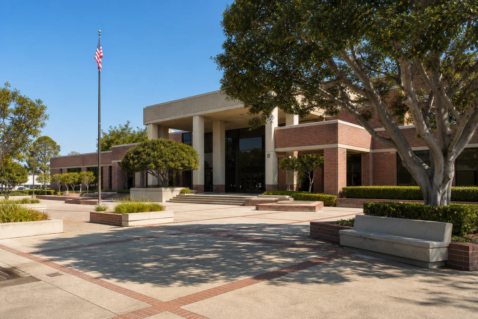 Brick municipal building, flagpole, and civic plaza representing Downey City Hall
