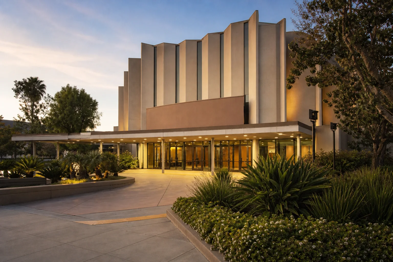 Mid-century theater facade and illuminated glass lobby representing Downey Theatre