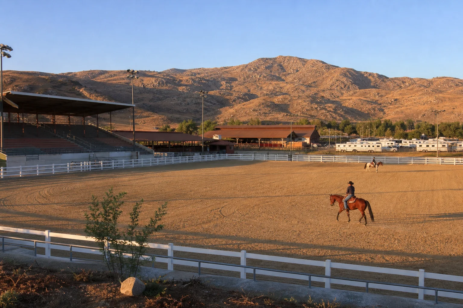 Equestrian arena, covered grandstand, and riders representing Ingalls Equestrian Event Center