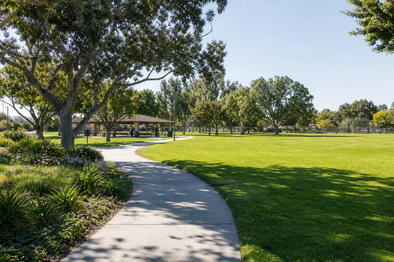 Open recreation lawn, shade trees, and walking path representing La Bonita Park