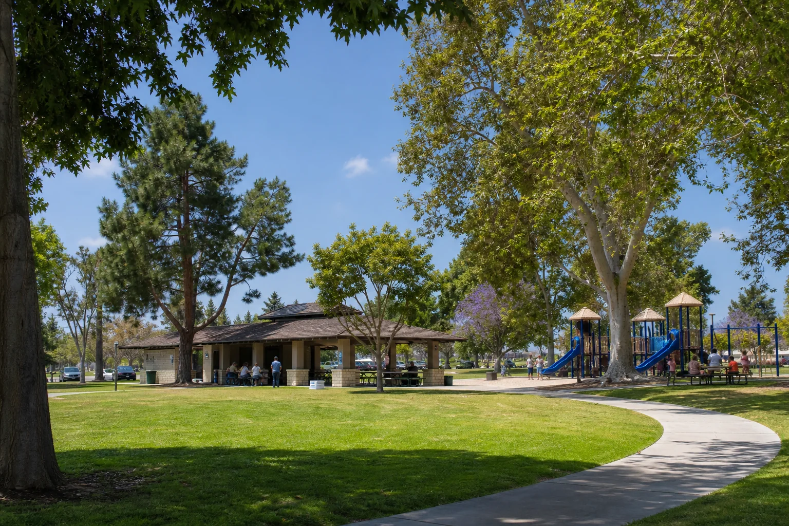 Shaded lawn, recreation pavilion, and playground representing Mayfair Park in Lakewood