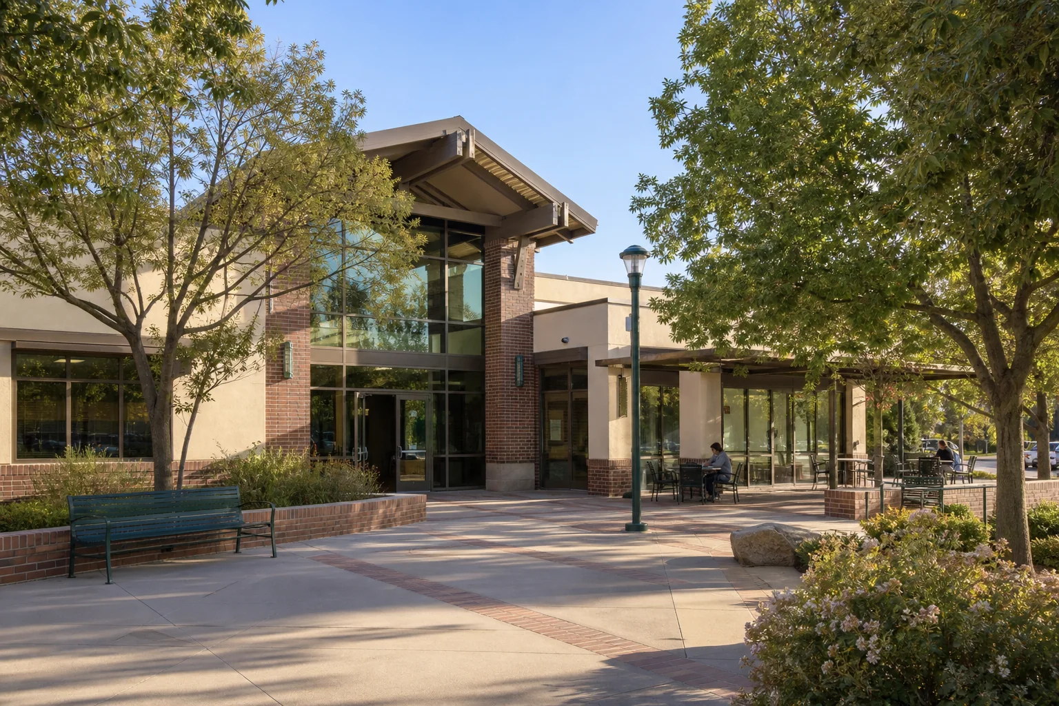 Modern public library entrance and shaded reading terrace representing the Placentia Library District