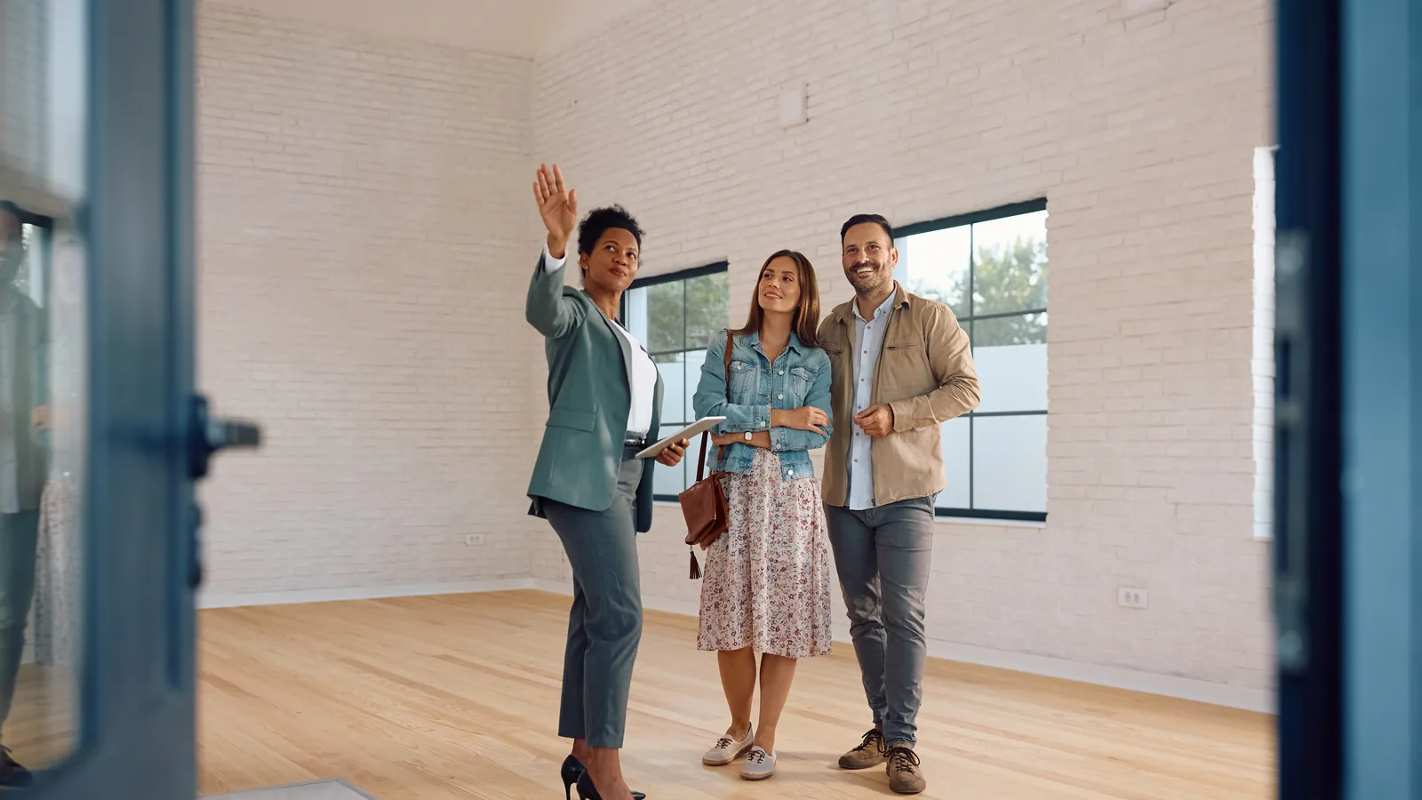 Real estate professional showing a bright property interior to clients