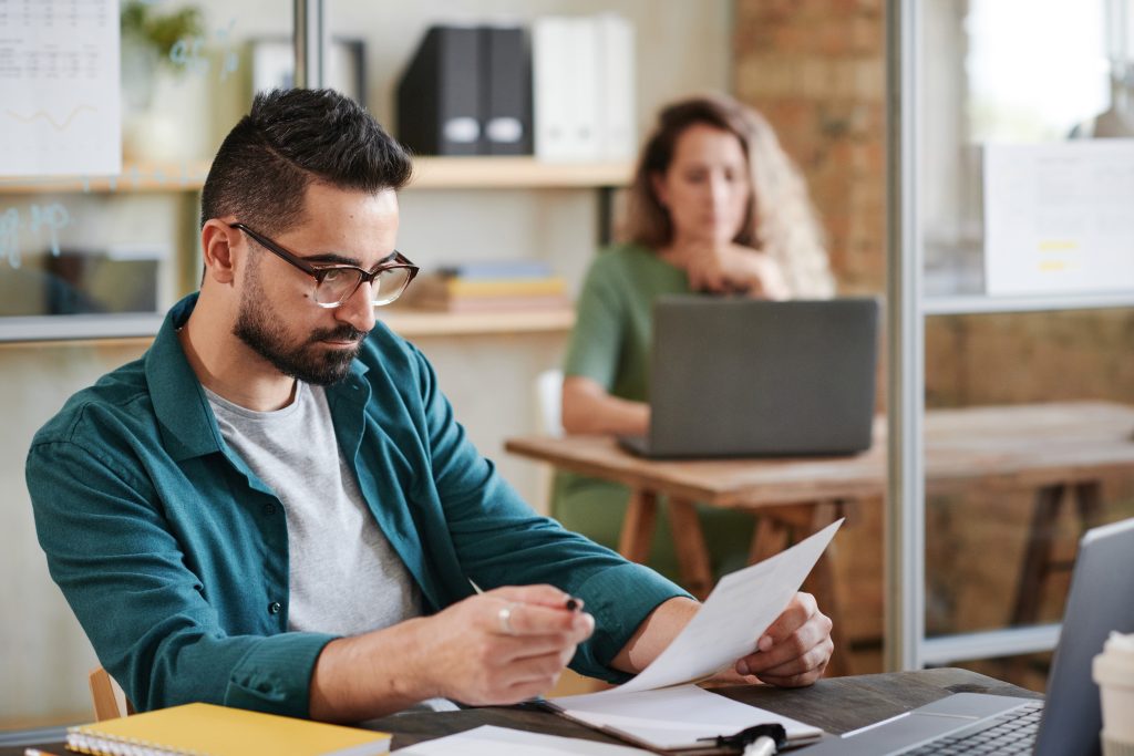 Focused professional reviewing documents in a modern office