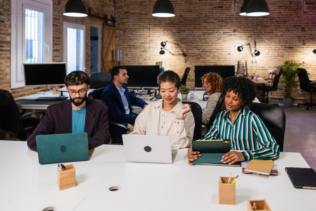 Team collaborating at laptops in a modern office