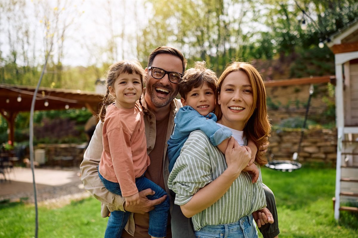 Family smiling together in a backyard while protecting home address privacy