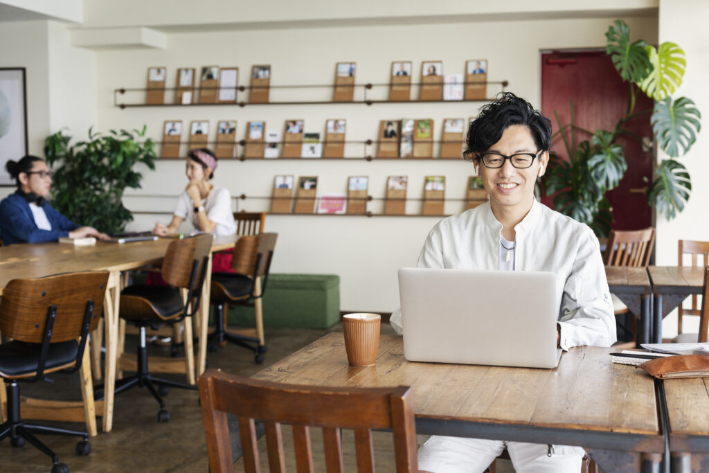 Smiling professional working on a laptop in a casual office