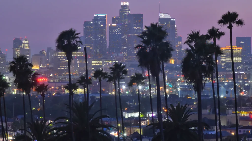 Los Angeles skyline at dusk with palm trees